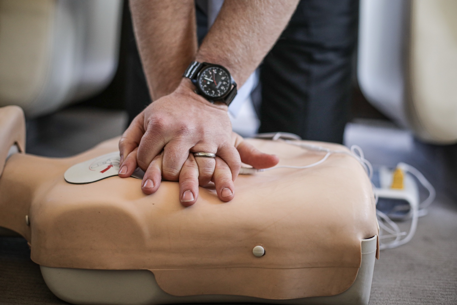 Practising chest compressions on a training manikin in an aircraft cabin